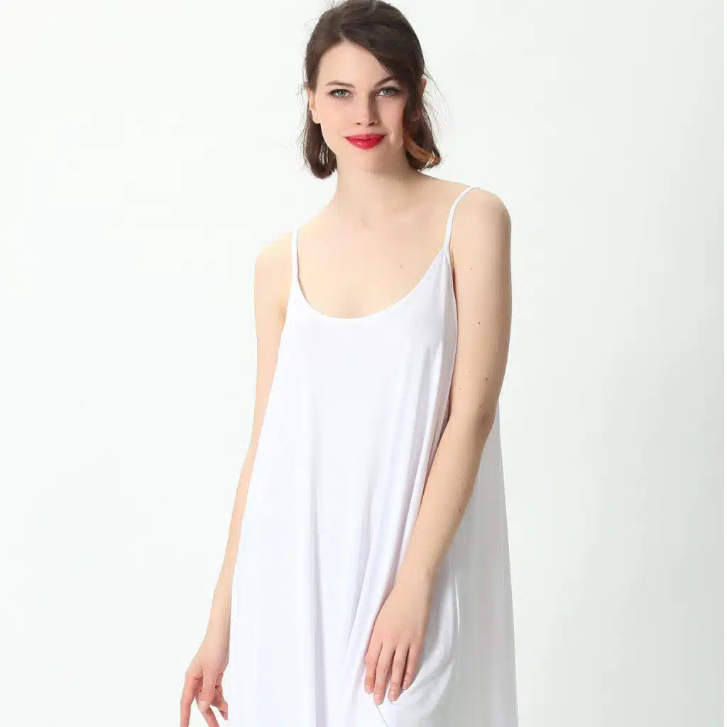 Femme portant une robe nuisette blanche ample mi-longue en coton