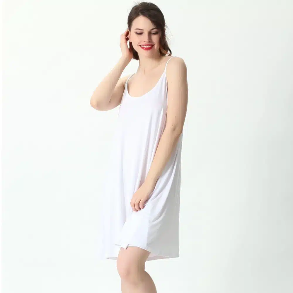Femme souriante portant une robe nuisette blanche ample mi-longue en coton