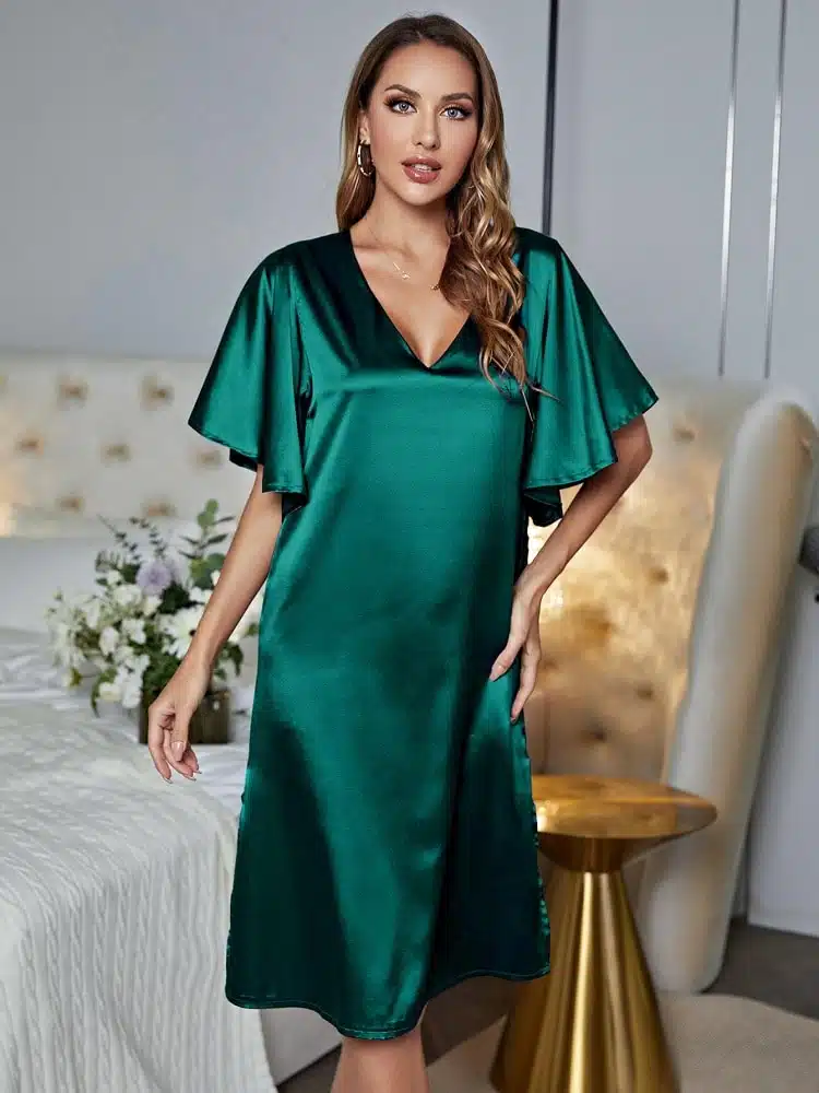 femme blonde portant une robe de nuit en satin verte avec des manches évasées